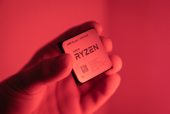 Quelqu'un tenant le Ryzen 7 5800X3D dans une lumière rouge.