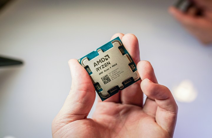 Une main tenant le Ryzen 9 9950X d'AMD.