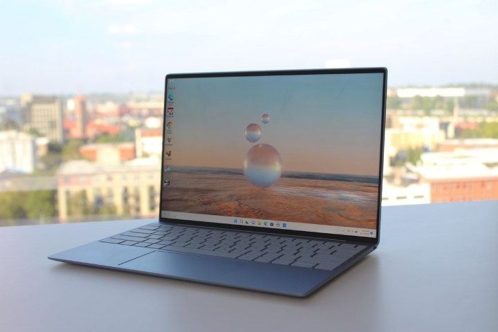 Le Dell XPS 13, ouvert sur une table devant une fenêtre.