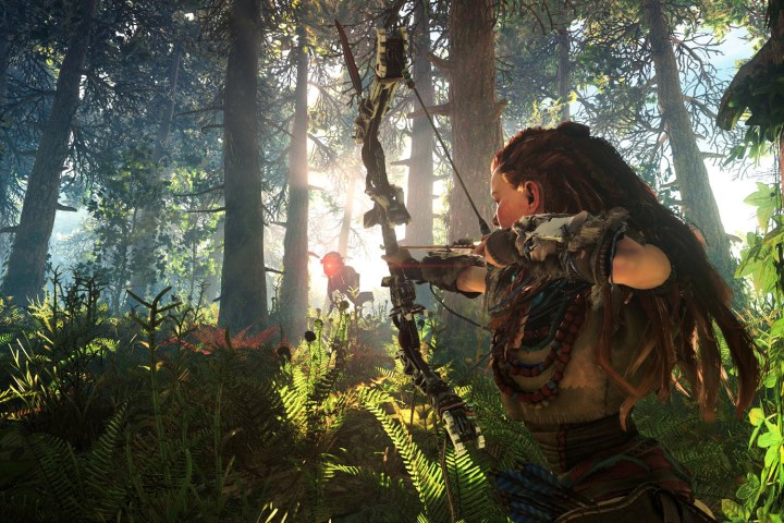Aloy visant son arc vers un robot dans une forêt.