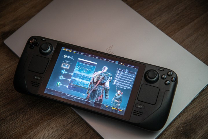 Le Steam Deck posé sur un ordinateur portable.