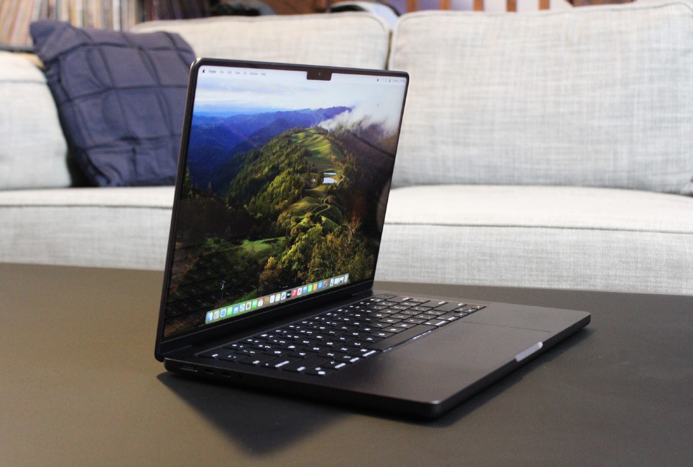 Le MacBook Pro ouvert sur une table devant un canapé.