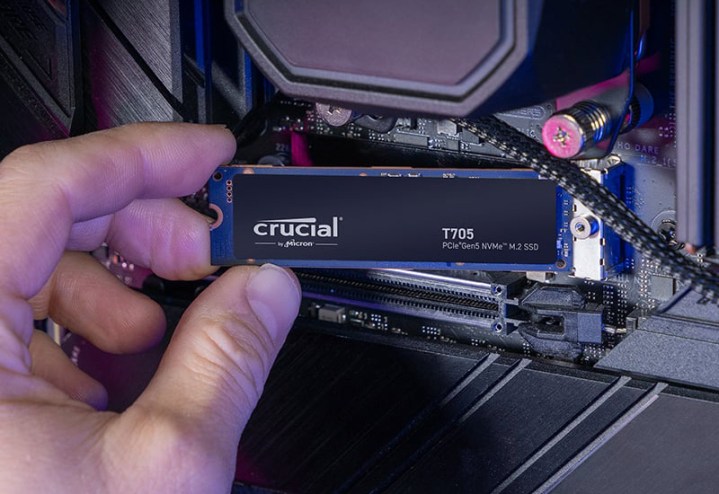 Le Crucial T705 PCIe 5.0 SSD tenu devant une carte mère.