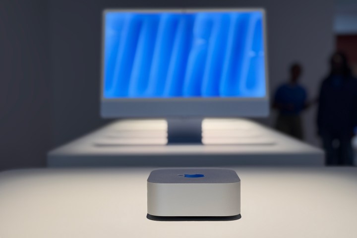 Le M4 Mac mini avec un écran en arrière-plan.