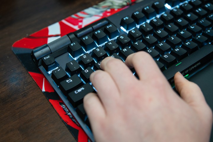 Des doigts posés sur WASD d'un clavier de jeu.
