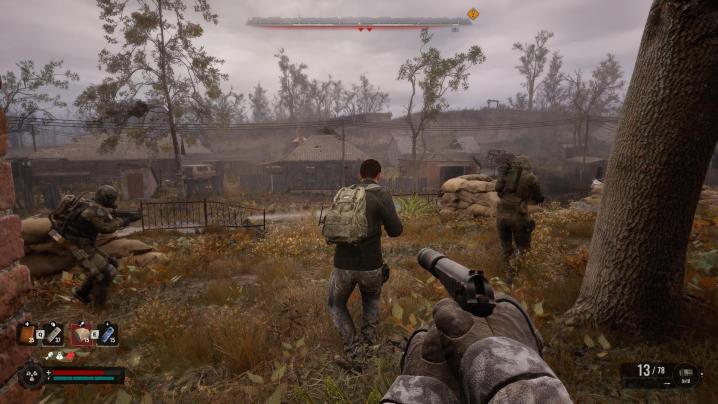The player advances with other faction mercenaries in a village in Stalker 2.