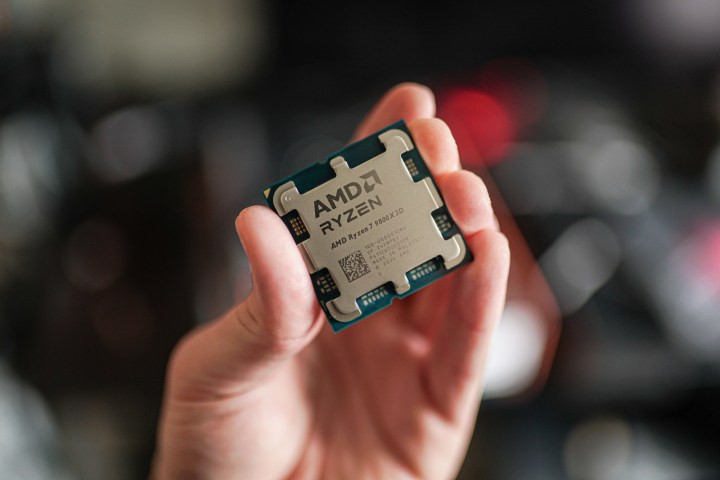 Le Ryzen 7 9800X3D tenu entre les doigts.