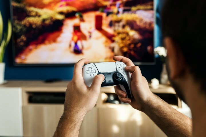 Une personne joue à Crash Bandicoot avec une manette PS5 DualSense.