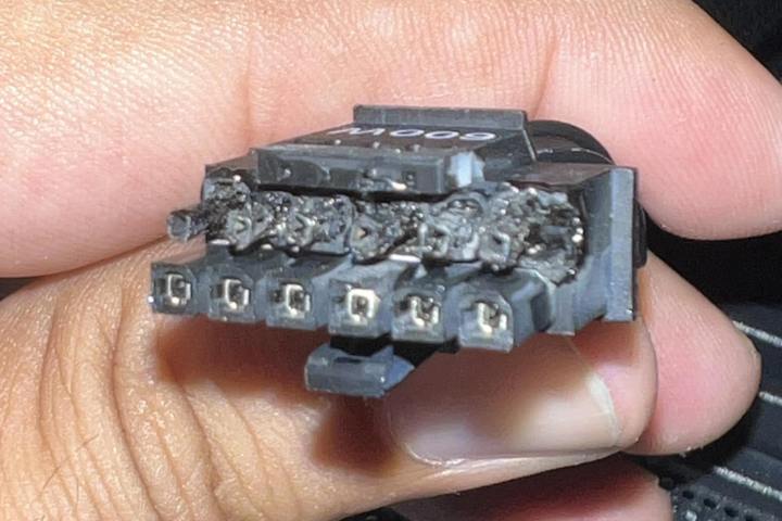 Une personne tient les connecteurs d'un câble Nvidia 12VHPWR d'une carte graphique RTX 4090. Les extrémités des connecteurs sont brûlées et fondues à cause d'une surchauffe.