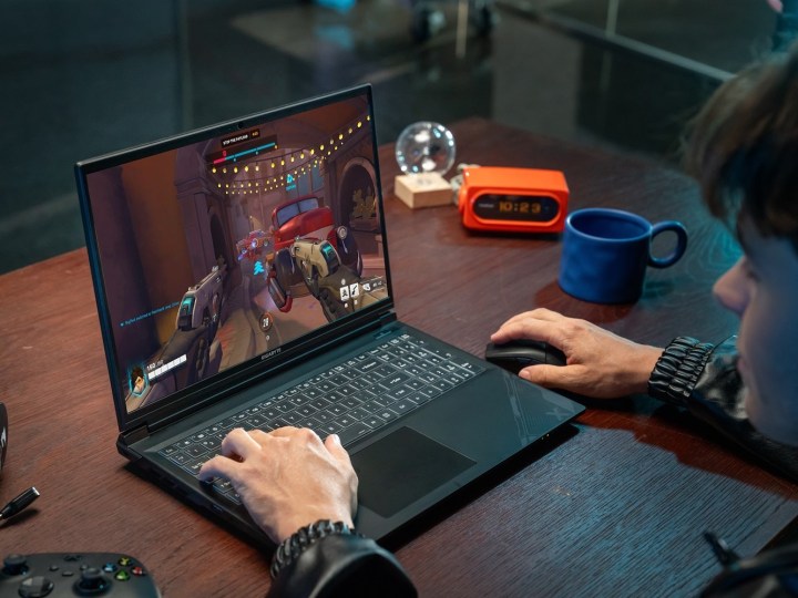 Gamer playing Overwatch on GIGABYTE G6X gaming laptop.