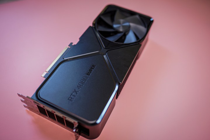 La carte graphique RTX 4080 Super posée sur un fond rose.