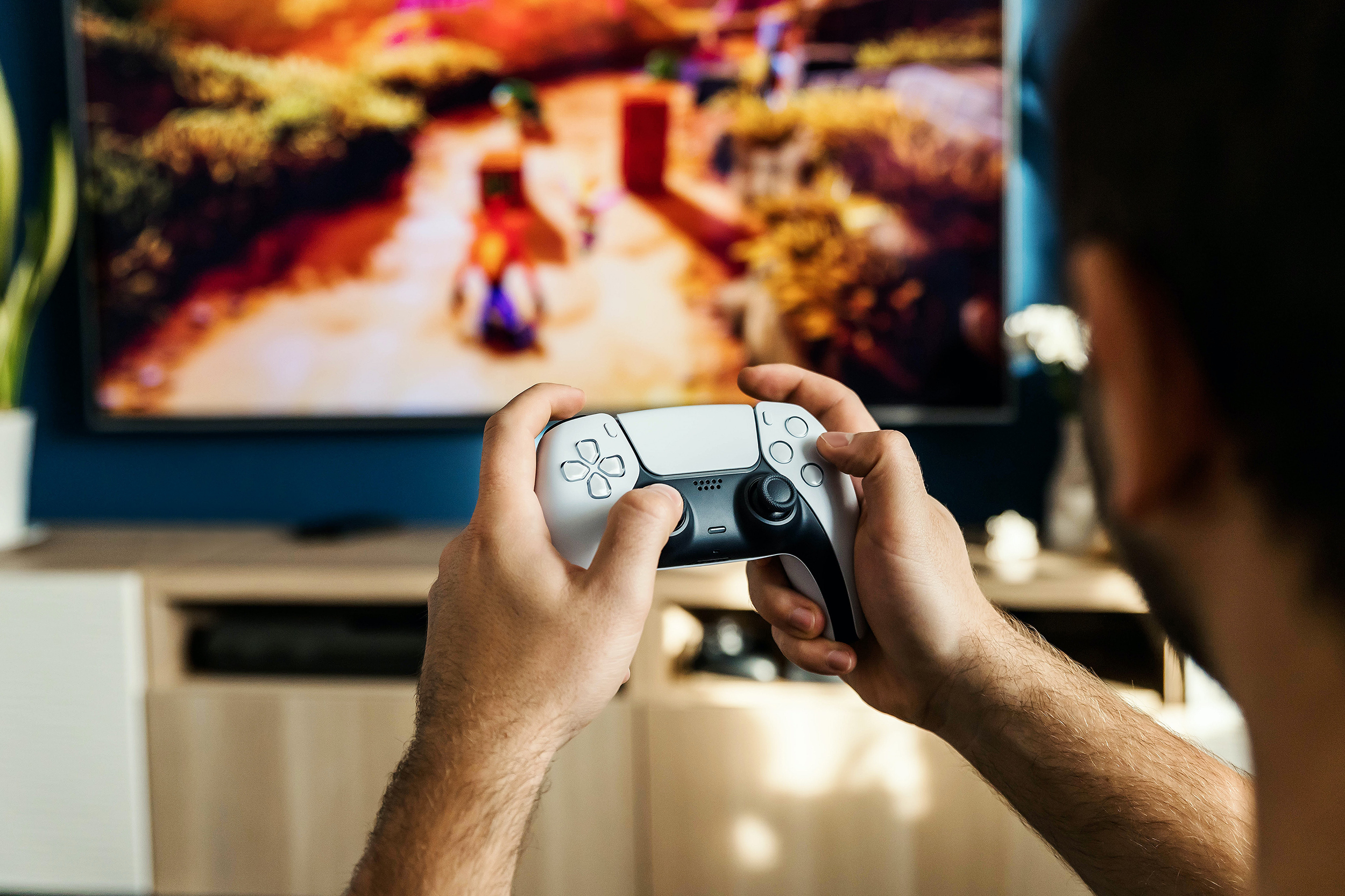 Une personne joue à Crash Bandicoot avec une manette DualSense de PS5.