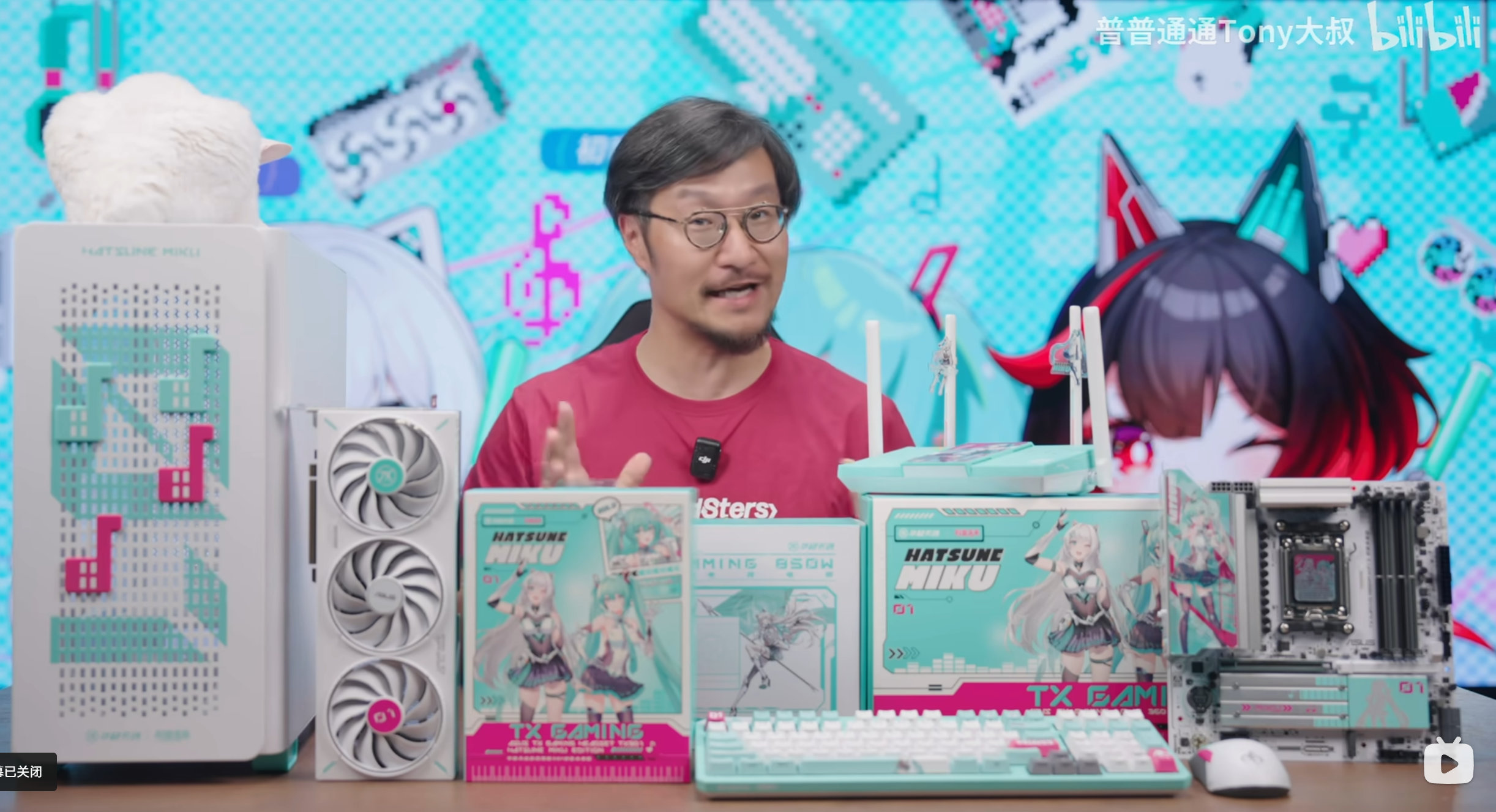 Un homme assis derrière une table avec beaucoup de matériel Asus x Hatsune Miku dessus.