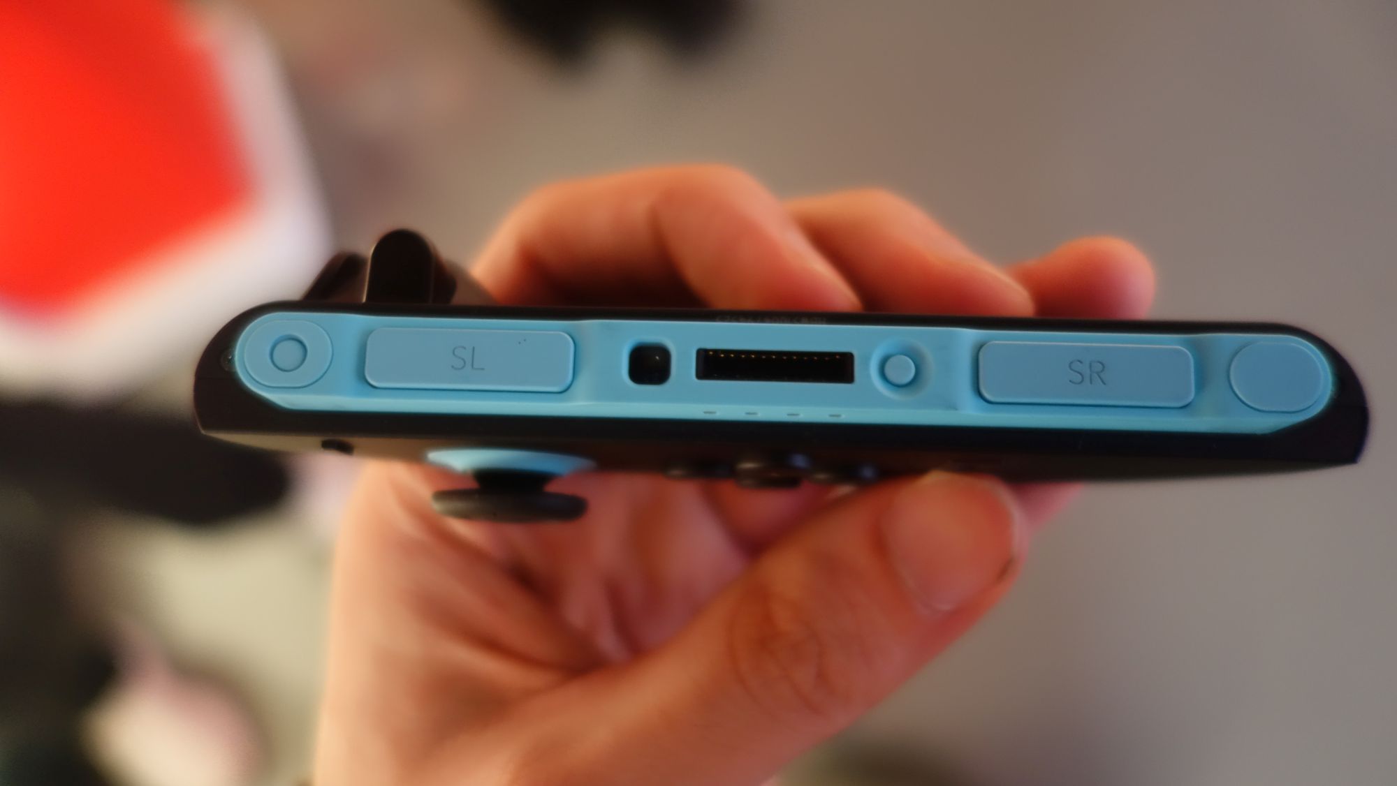 Une main tenant un Joy-con de Switch 2.