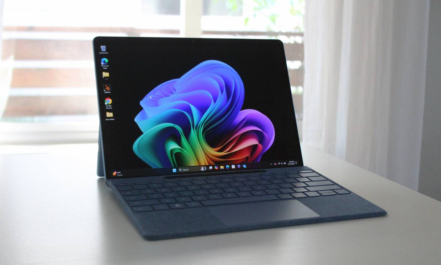 Le Surface Pro 11 sur une table blanche devant une fenêtre.