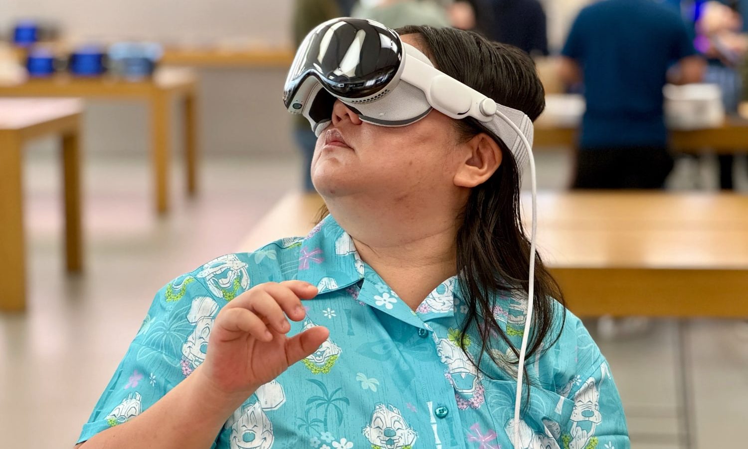 Une personne portant l'unité de démonstration Apple Vision Pro dans un magasin Apple.