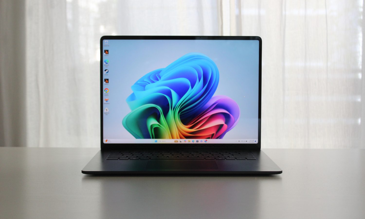 Le Surface Laptop 7 sur une table devant une fenêtre.