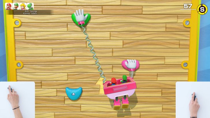Two characters in a pink claw climbing wall, with hands controlling joysticks, playful scene.