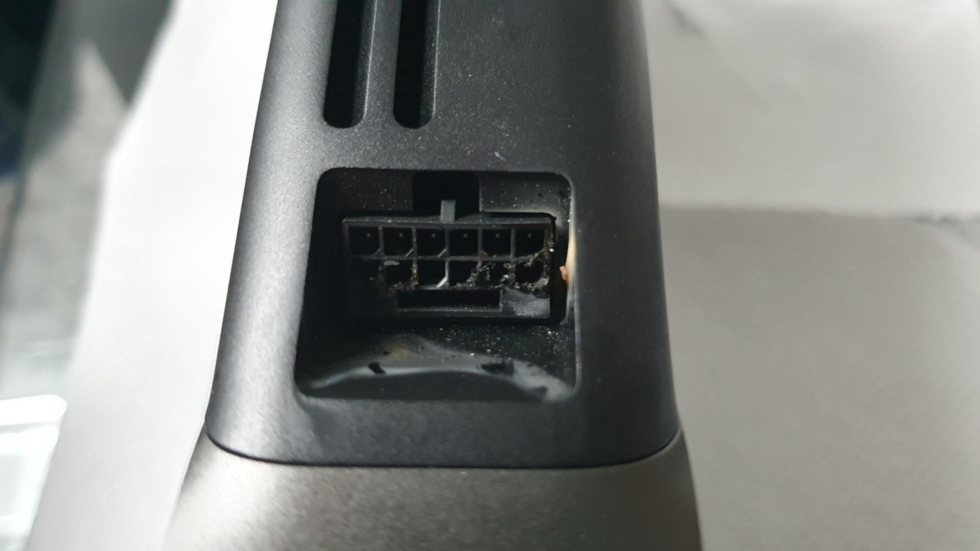 Close-up of a damaged electronic connector port on a black device.