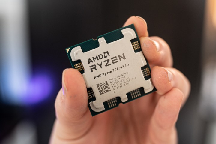 AMD Ryzen 7 7800X3D tenu entre deux doigts.