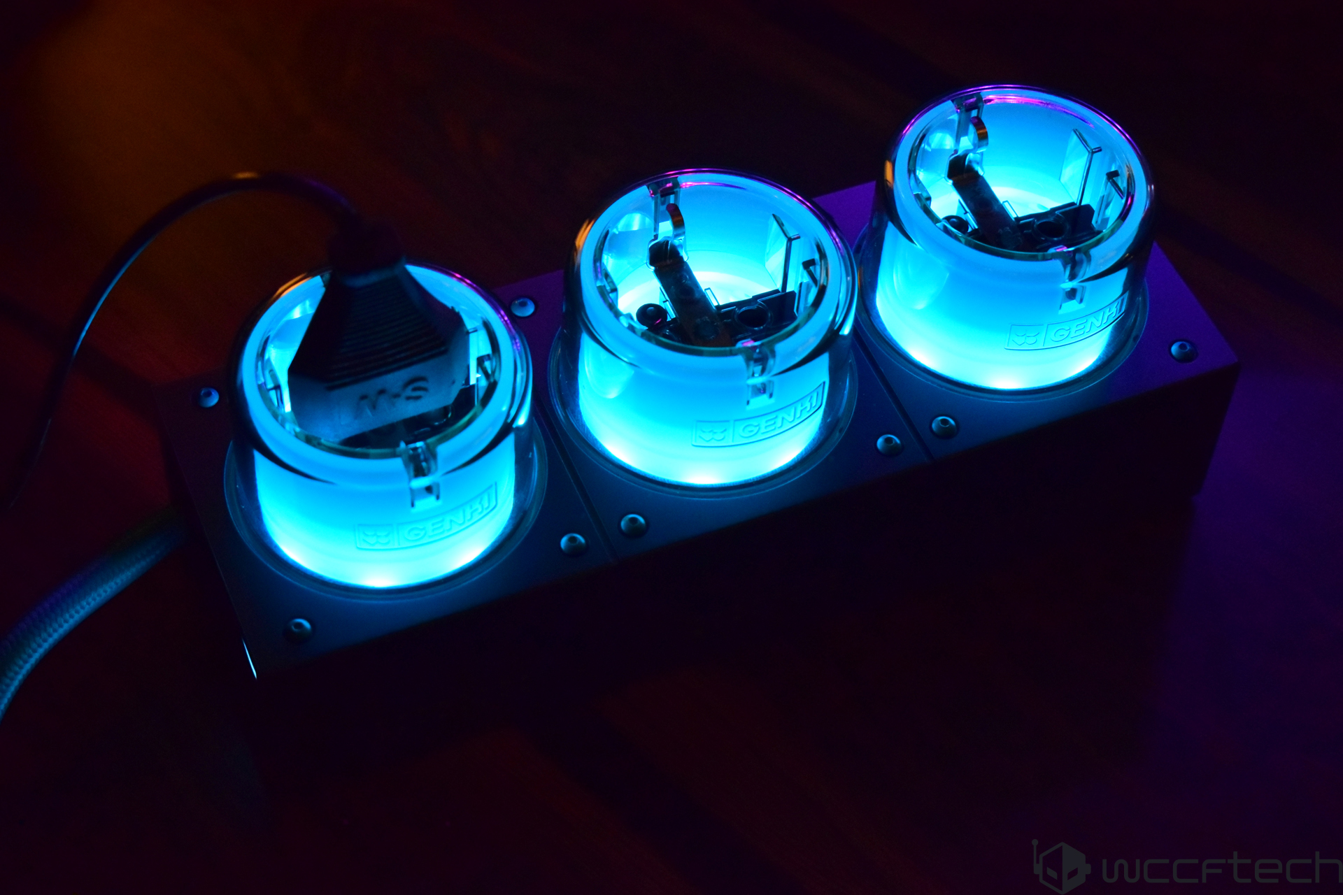 Blue LED light device with three glowing sockets on a dark background.