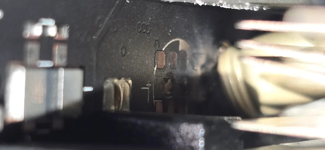 Détail des mécanismes internes d'un appareil électrique montrant des composants métalliques.