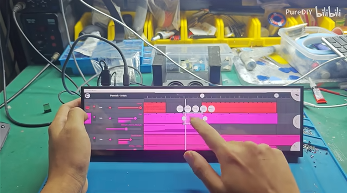 Personne utilisant un écran tactile pour l'édition musicale.