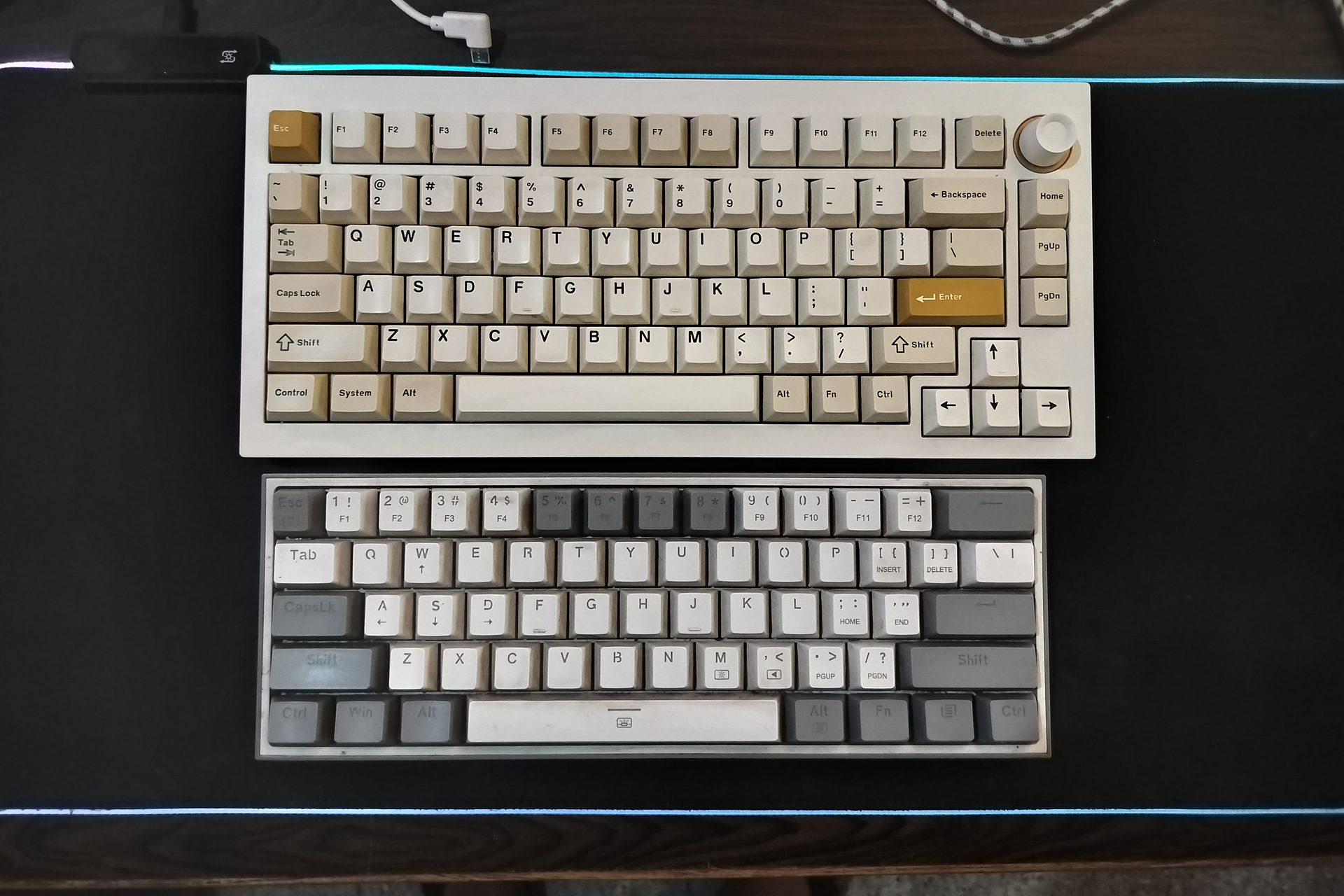 Claviers sans marque sur un tapis de bureau noir.