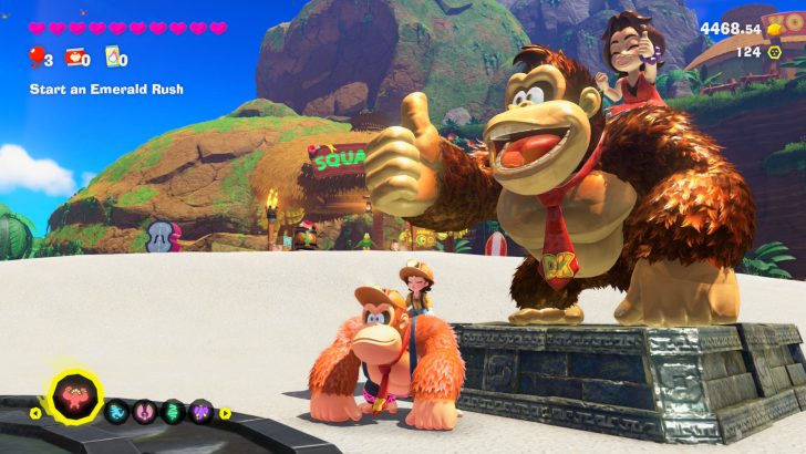 Statue Donkey Kong Bananza avec une scène de jeu vidéo montrant le début d'Emerald Rush.
