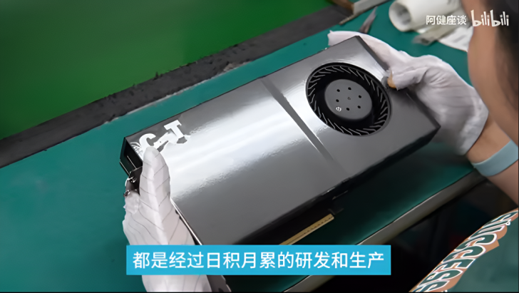 Un employé assemble un GPU avec précision sur un banc de travail.