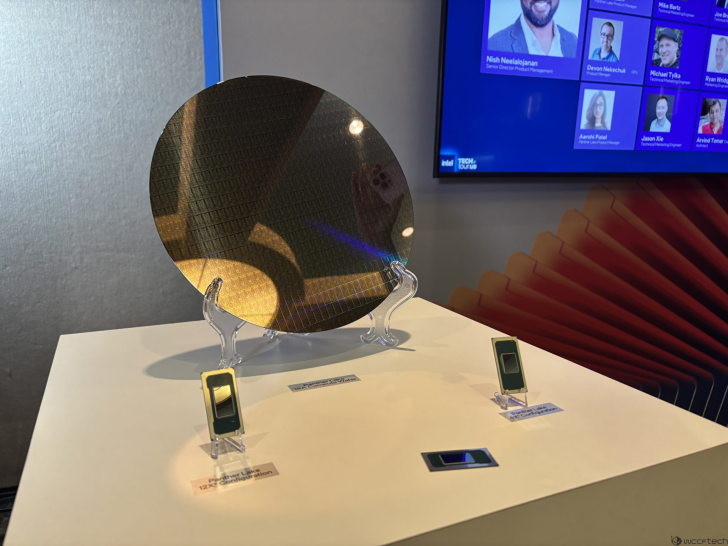 Affichage du Tech Tour d'Intel avec un wafer de silicium et des processeurs étiquetés Meteor Lake 12e Gén. sur une table blanche.