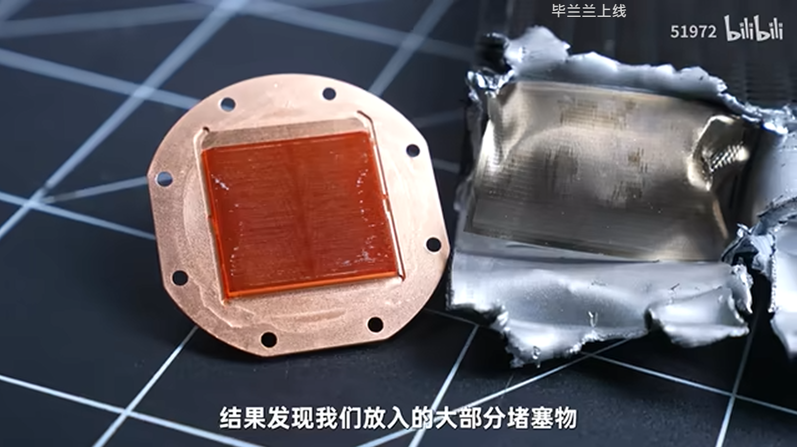 Copper heat sink with a red core next to torn metal foil on a patterned surface, text reads 结�我们大部分堵塞物 and brand bilibili.