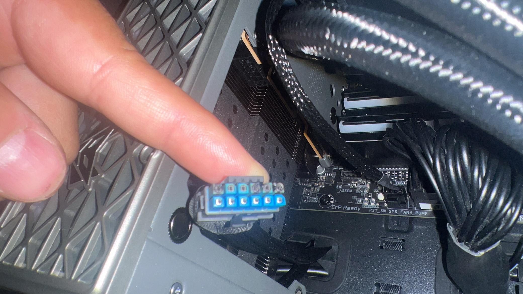 Un doigt pointe vers un connecteur interne de PC non identifié avec ERP Ready sur la carte mère.