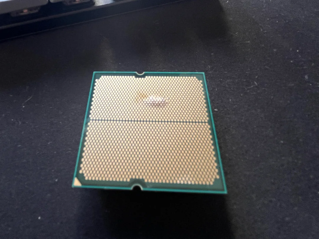 Image d'un CPU AMD épuré avec des pin visibles.