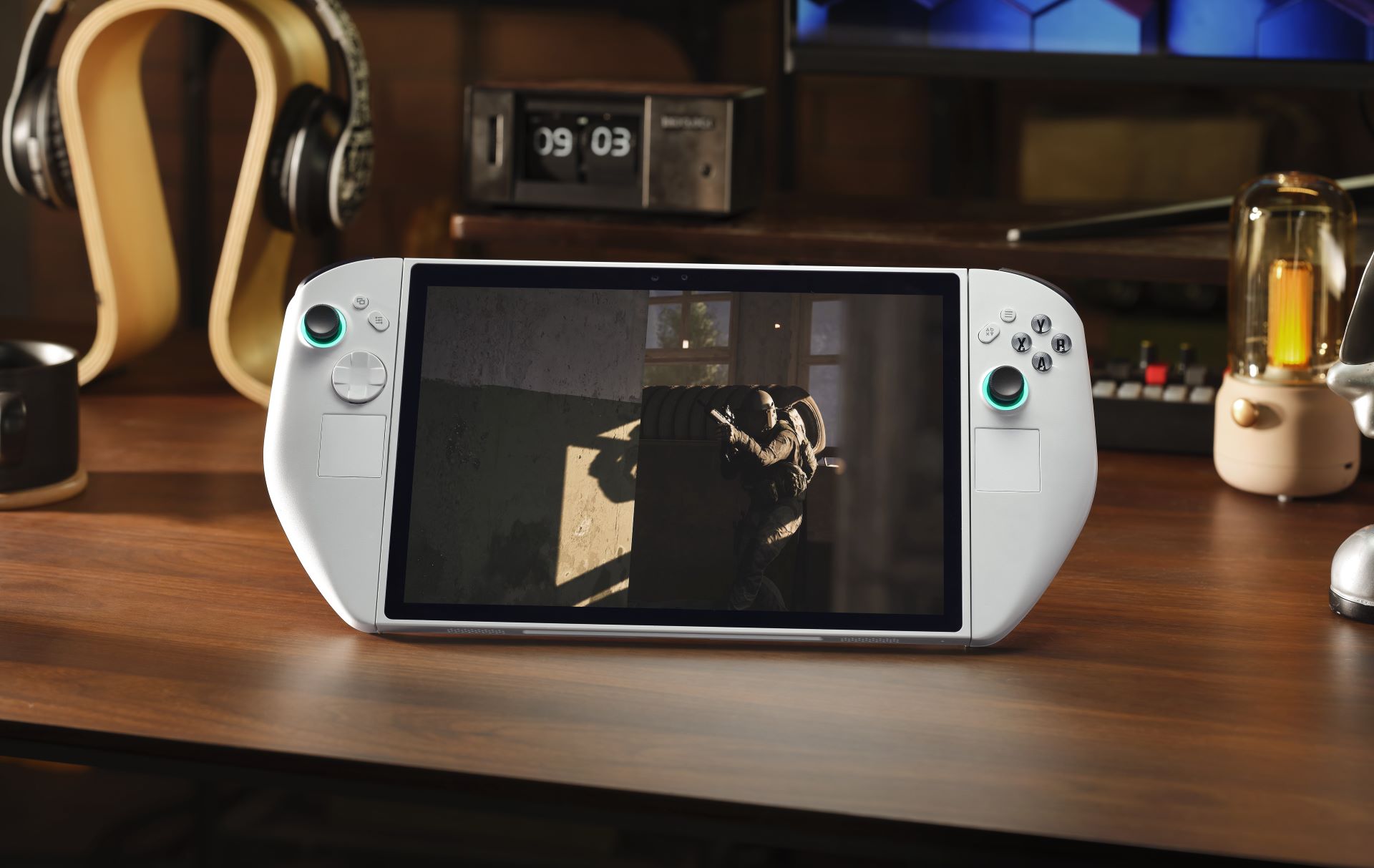 Console de jeux portable affichant un jeu de tir tactique sur un bureau en bois.