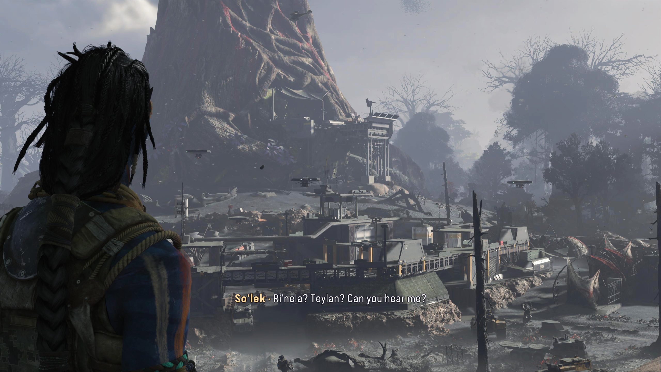 Un personnage dans 'Avatar: Frontiers of Pandora' observe une base militaire