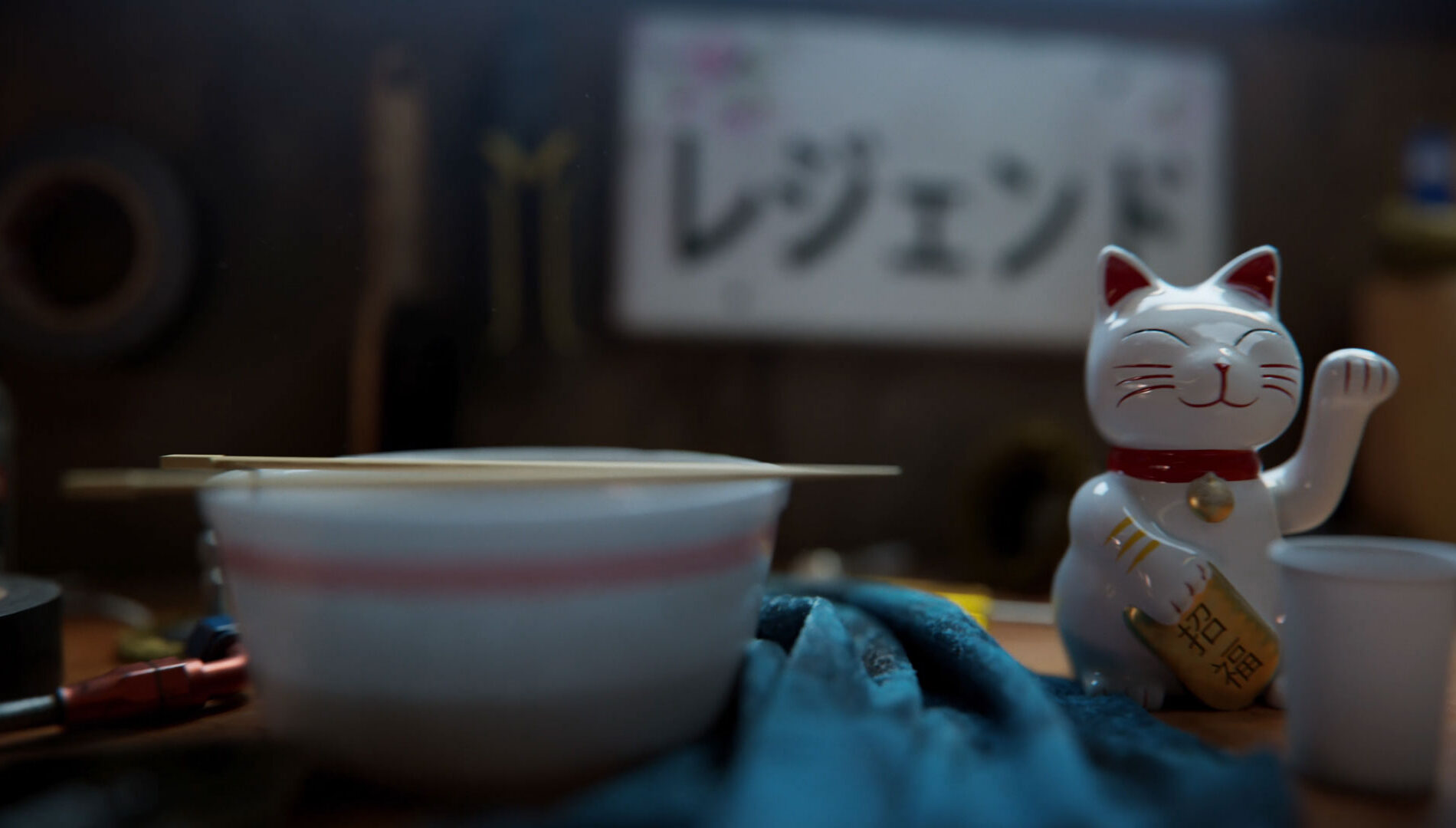 Un chat chanceux japonais à côté d'un bol et de baguettes, en arrière-plan un texte japonais pour Forza Horizon 6