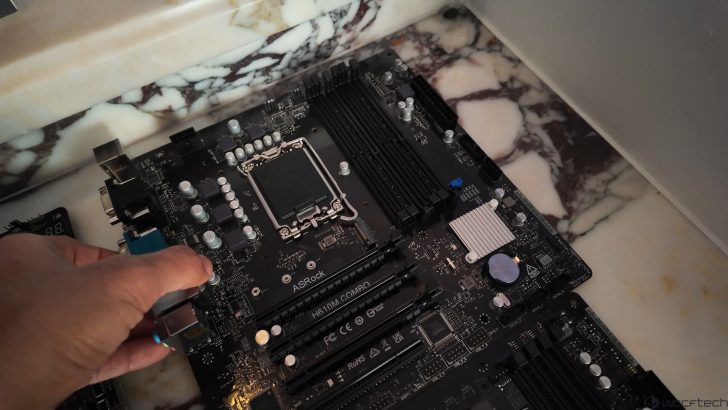 Assemblage d'une carte mère ASRock H610M Combo sur une surface en marbre.