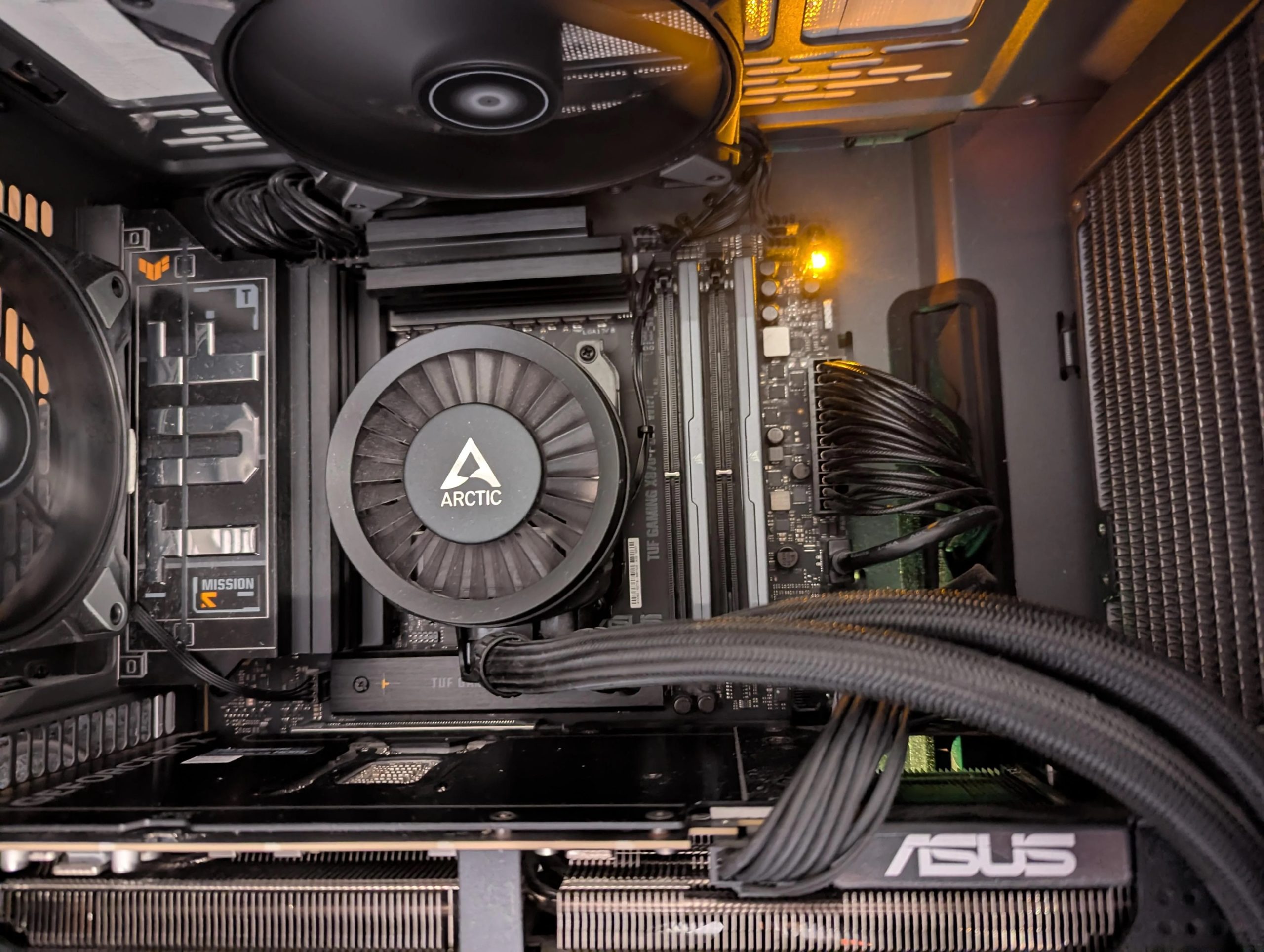 Intérieur d'un boîtier d'ordinateur avec un refroidisseur CPU Arctic, une carte graphique ASUS et une carte mère TUF Gaming