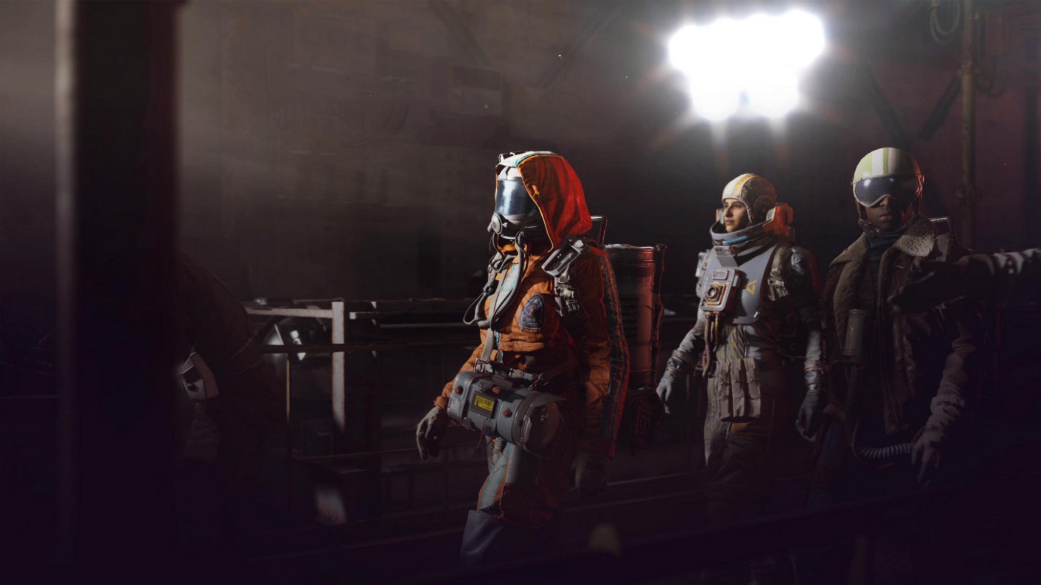 Three characters in space suits exploring a dark industrial environment in the game 'ARC Raiders'.