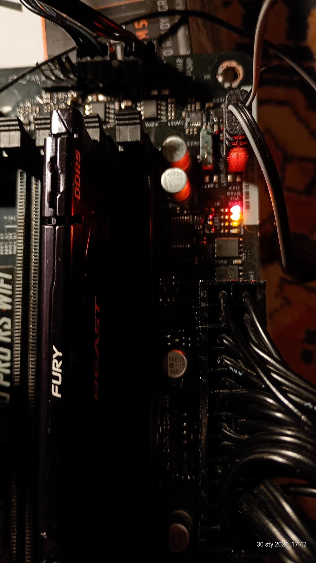 Une carte mère avec des modules RAM Kingston Fury Beast DDR5 et un label ASRock 'PRO RS WIFI', avec des LED