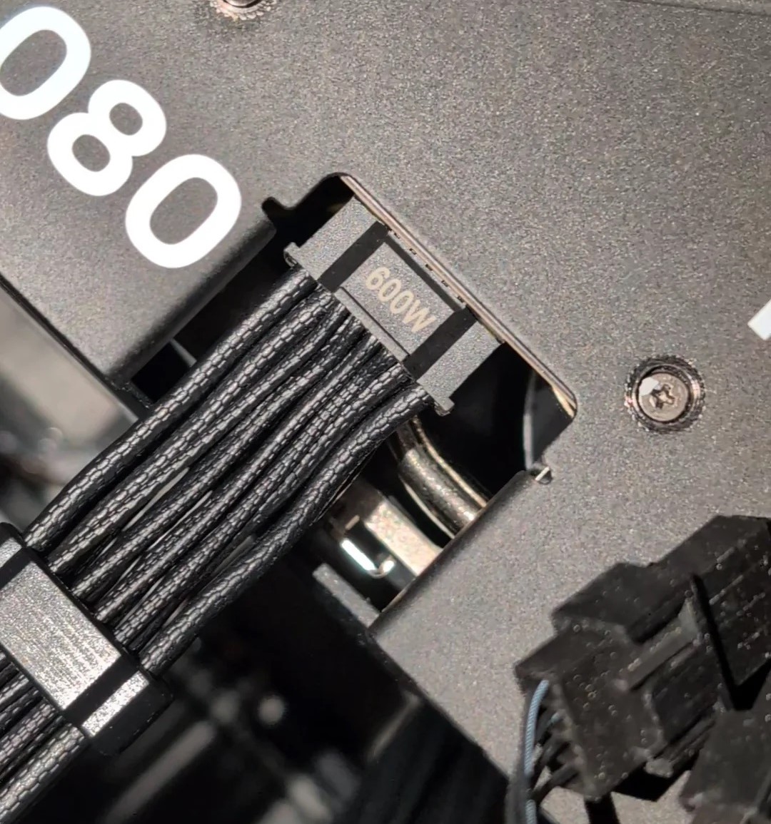 Détail d'un câble étiqueté '600W' connecté à une carte graphique.