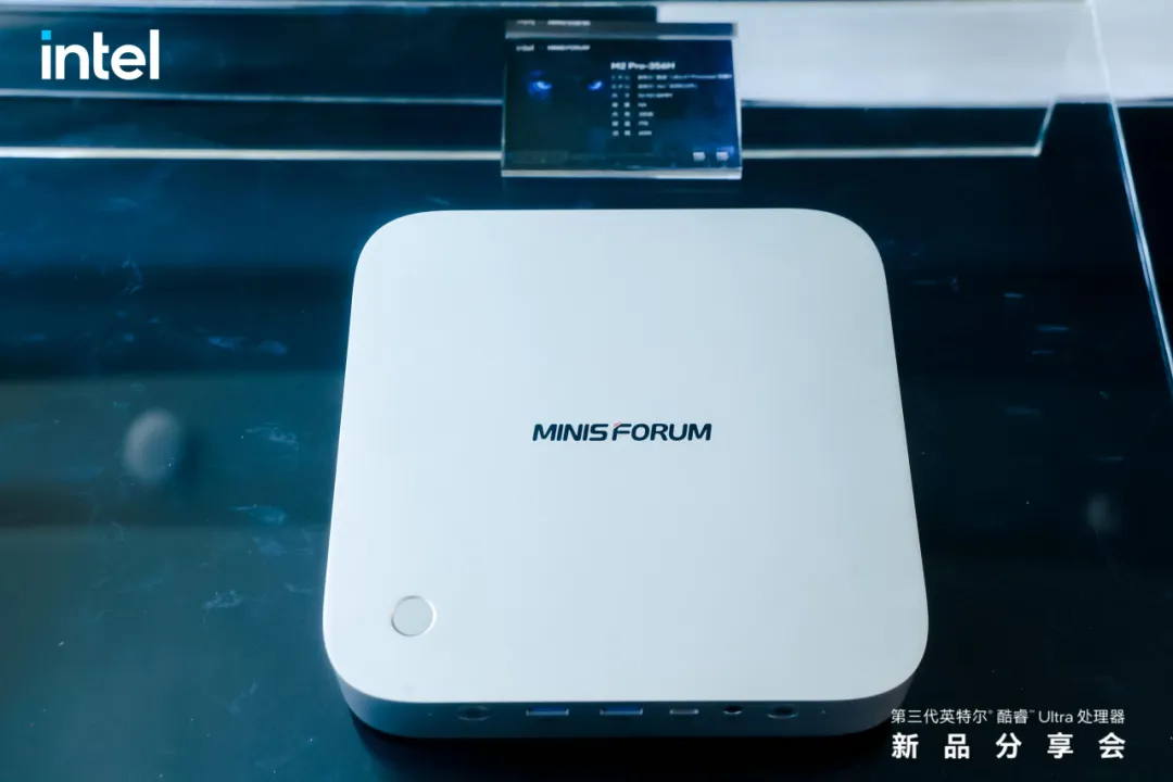 Un mini PC Minisforum avec un branding Intel affiché sur une surface réfléchissante.
