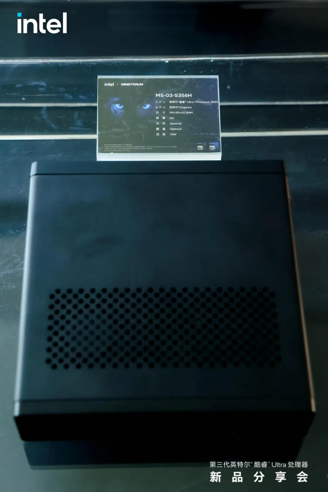 Un boîtier de bureau noir de Minisforum à côté d'une carte affichant 'MS-03-S356H' avec un 'Core Ultra 7 Processor 356H' à 70W.