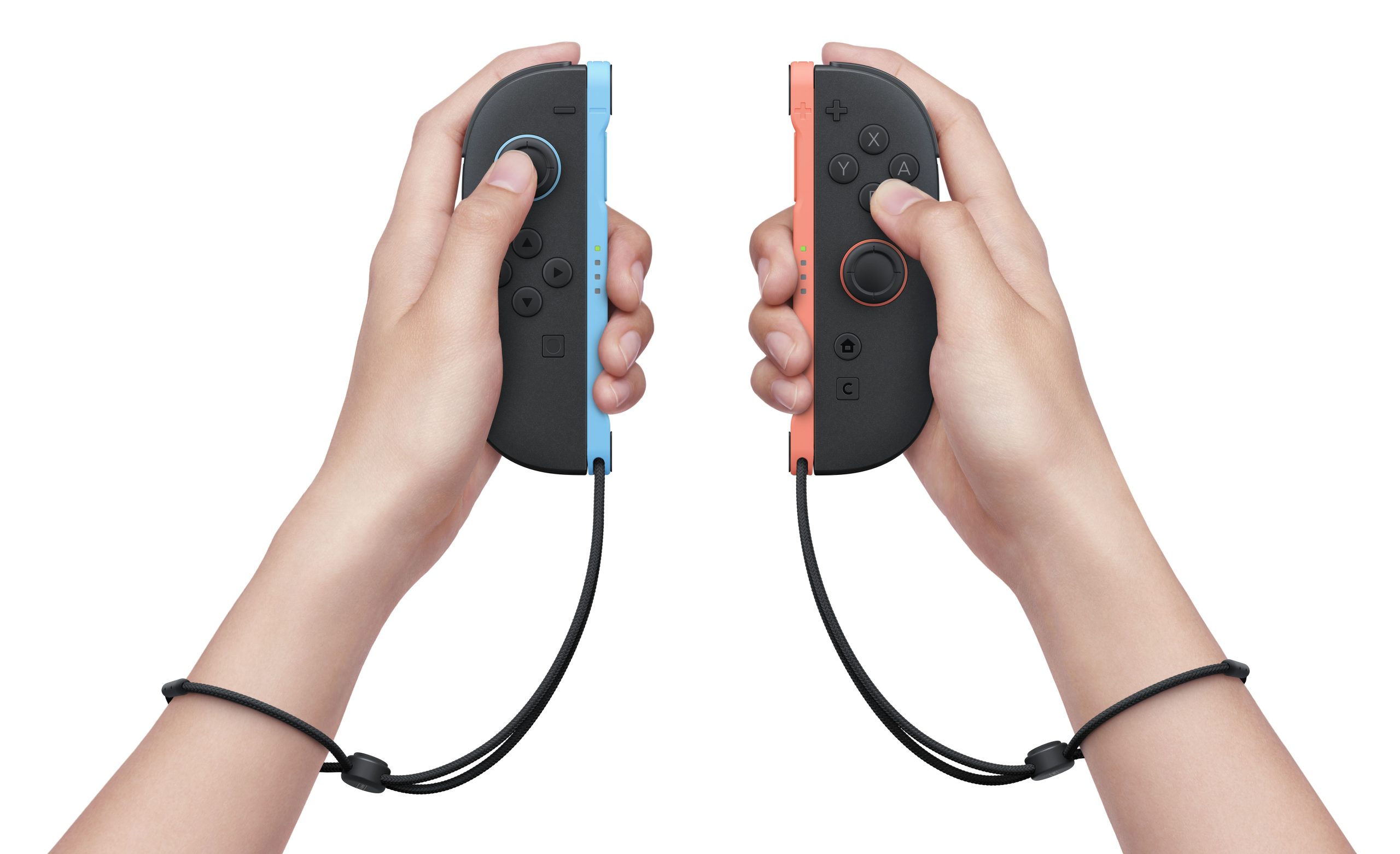 Two hands holding Nintendo Switch Joy-Con controllers, with the left one in neon blue and the right one in neon red.