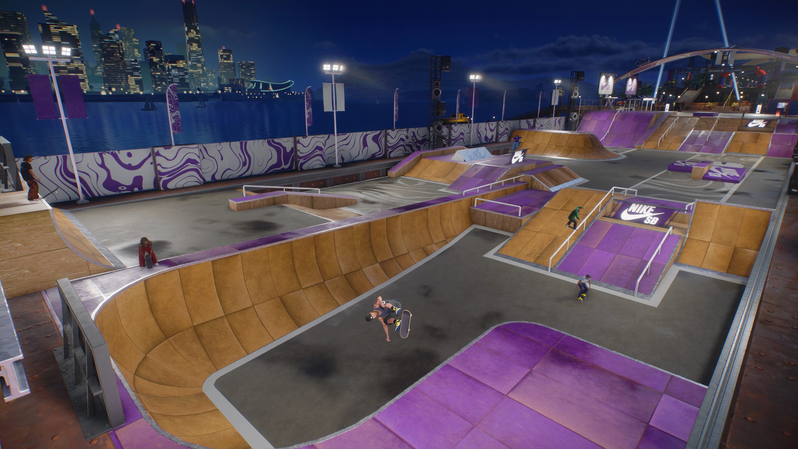A skateboarder performs a mid-air trick at a skatepark with prominent 'Nike SB' branding and a city skyline in the background.