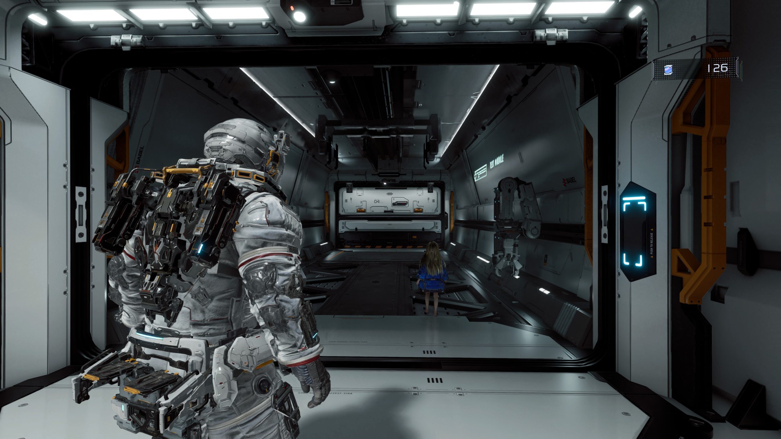 A character in an armored suit stands in a futuristic corridor with a seated figure in the distance, with the text 'BB MODULE' visible on the wall.