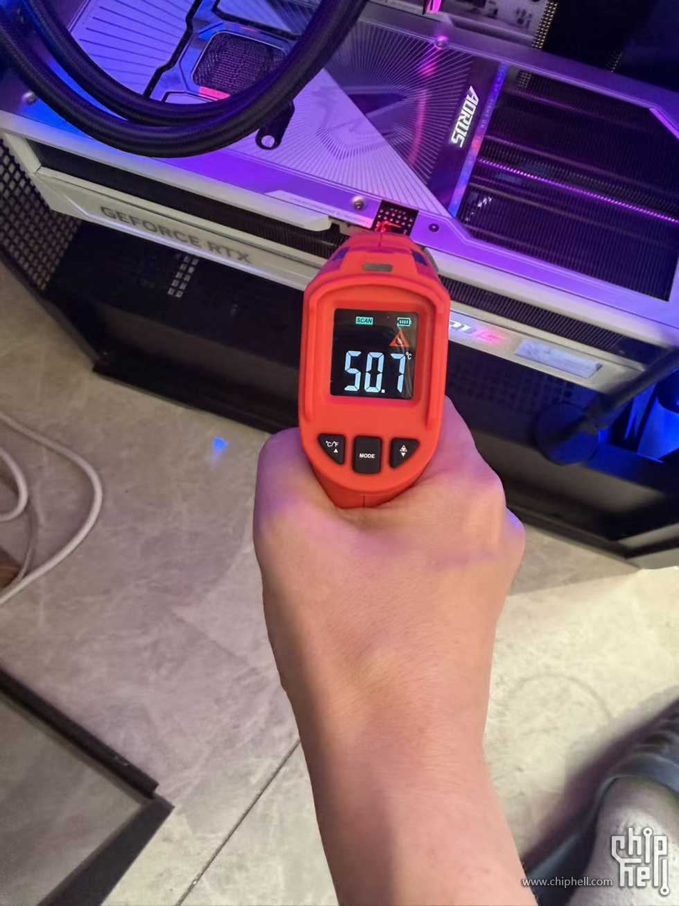 Un thermomètre affiche 50,1 °C en mesurant une carte AORUS 'GEFORCE RTX' dans un boîtier.