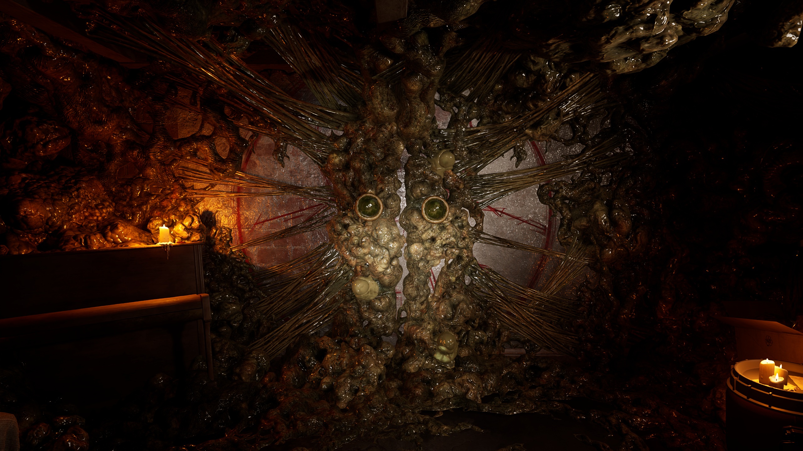 A dark, eerie environment featuring an organic, grotesque wall formation with two green, eye-like structures, illuminated by nearby candles.