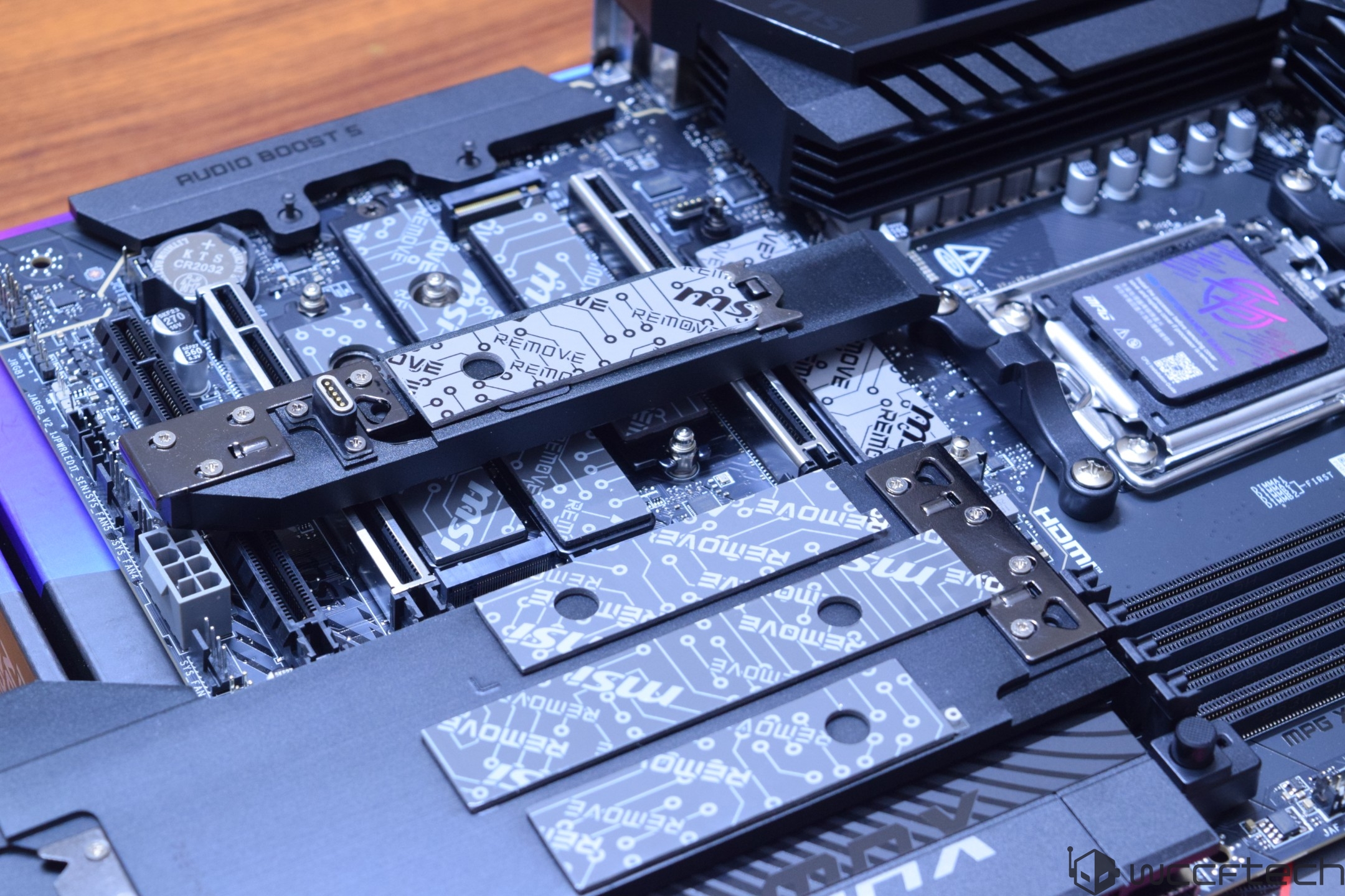 Gros plan d'une carte mère ASUS avec une carte M.2 MSI Gen5 et 'AUDIO BOOST 5' sur le dissipateur thermique.